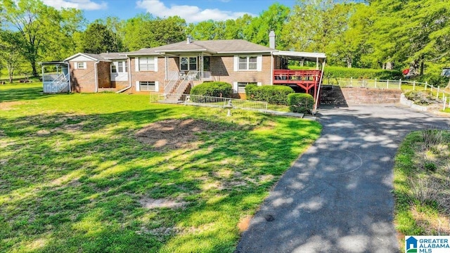ranch-style house featuring a front lawn, brick siding, fence, and stairway
