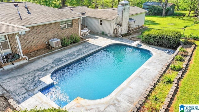 pool with a lawn, a patio area, a fenced backyard, and central AC