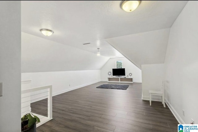 bonus room with baseboards, vaulted ceiling, and wood finished floors