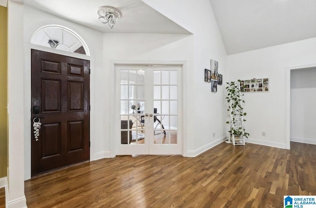 entrance foyer with vaulted ceiling, french doors, and wood finished floors