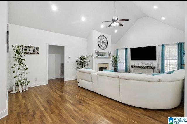 living room with ceiling fan, a fireplace, wood finished floors, high vaulted ceiling, and a wealth of natural light