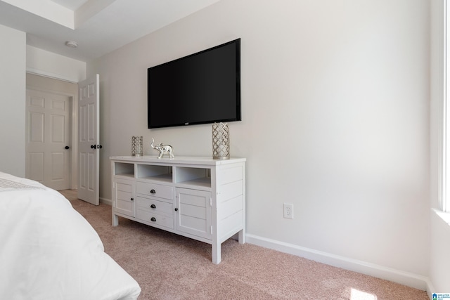 bedroom featuring light carpet and baseboards