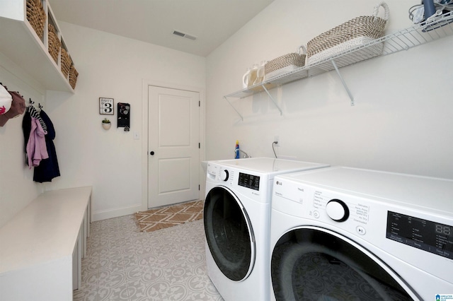 laundry area featuring washing machine and dryer, laundry area, visible vents, baseboards, and light floors