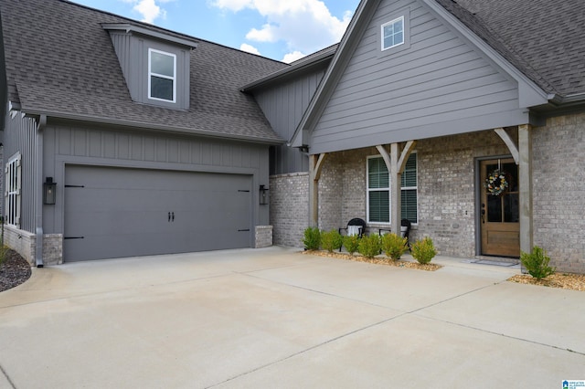 craftsman-style home with a garage, brick siding, a shingled roof, and driveway