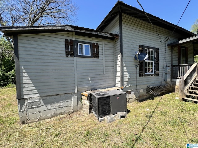 view of side of home featuring a yard and central AC unit