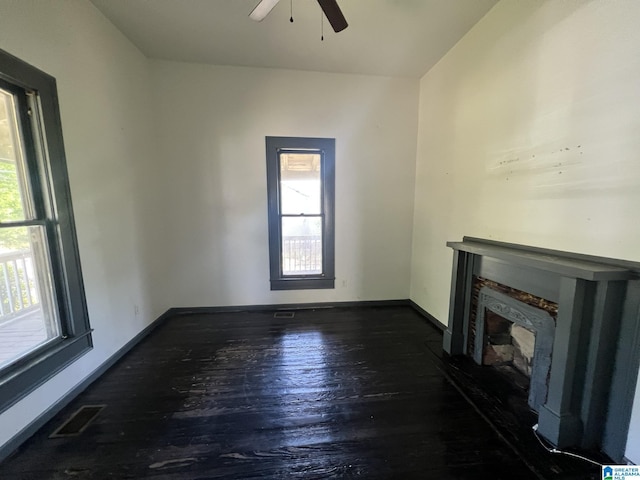 unfurnished living room featuring visible vents, baseboards, a ceiling fan, and wood finished floors