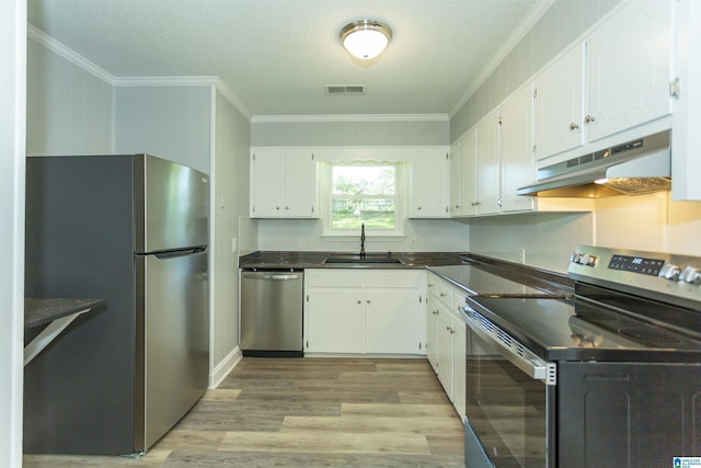 122 Mims Cir, Clanton, AL 35045 - kitchen with stainless steel appliances, under cabinet range hood, ornamental molding, light wood-style floors, and dark countertops