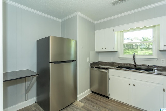 122 Mims Cir, Clanton, AL 35045 - kitchen featuring stainless steel appliances, wood finished floors, crown molding, white cabinets, and a textured ceiling