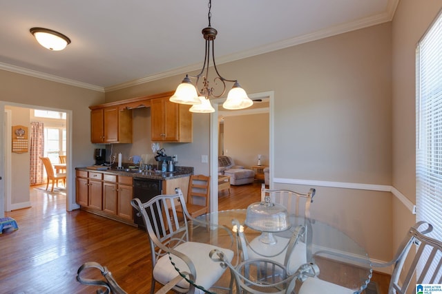 dining space featuring baseboards, ornamental molding, and wood finished floors