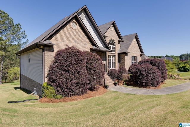 view of side of property with a yard and brick siding