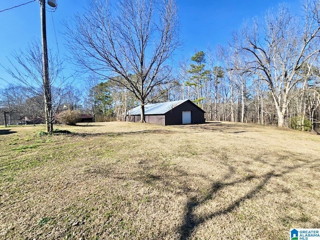 view of yard with a detached garage, a pole building, and an outdoor structure