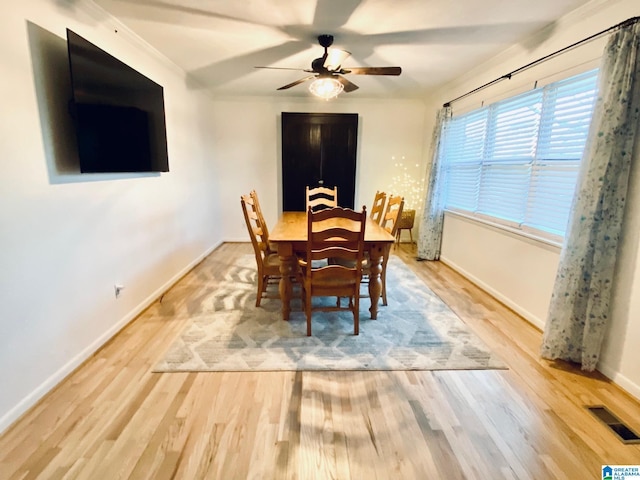 dining room with visible vents, baseboards, ceiling fan, and wood finished floors