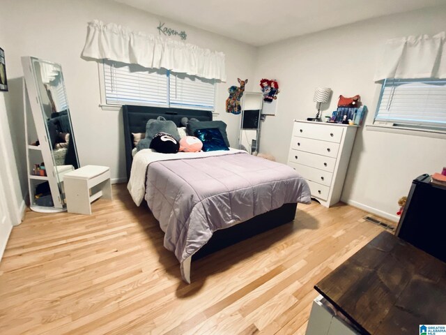 bedroom featuring visible vents, baseboards, and light wood-style floors