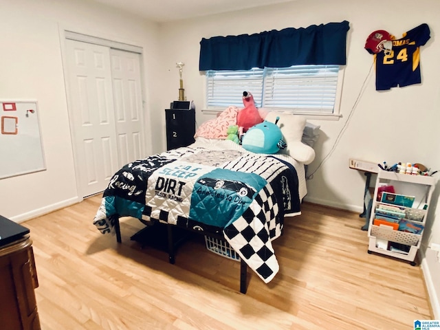 bedroom featuring a closet, baseboards, and wood finished floors