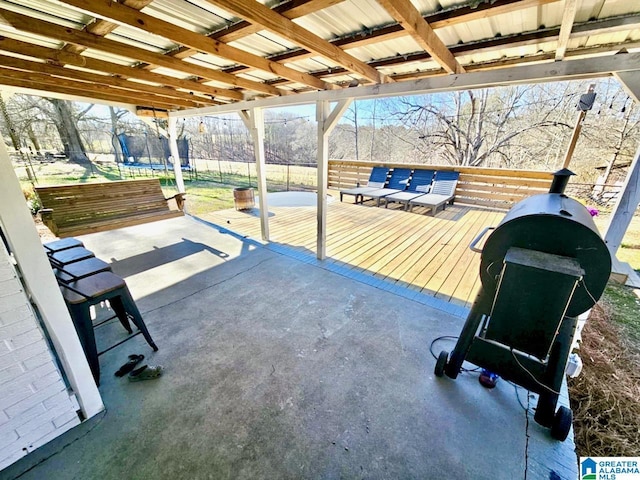 view of patio with a trampoline and fence
