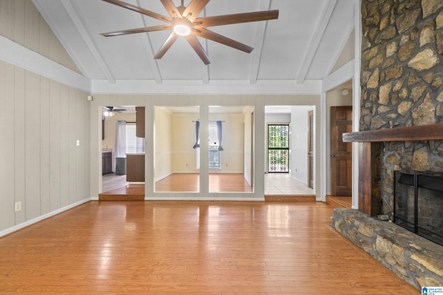 unfurnished living room with light wood-type flooring, vaulted ceiling with beams, and ceiling fan