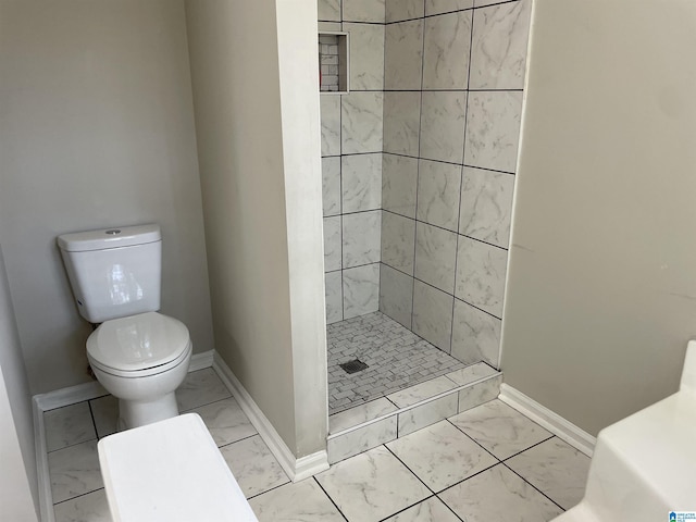 54 Setter Dr, Anniston, AL 36207 - bathroom featuring marble look tiles, toilet, baseboards, and a shower stall
