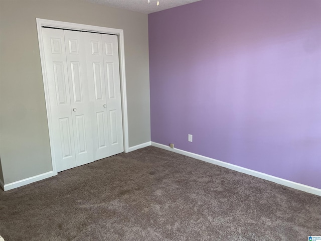 54 Setter Dr, Anniston, AL 36207 - unfurnished bedroom featuring dark carpet, baseboards, and a closet