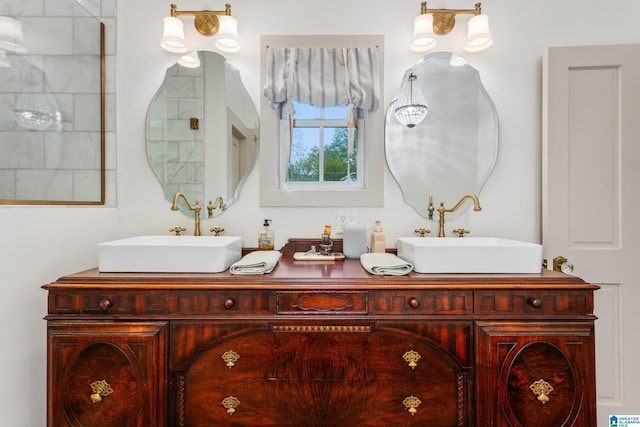 bathroom with a sink, a shower, and double vanity