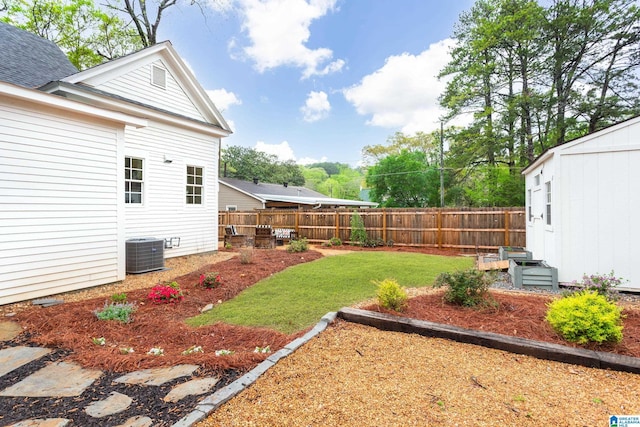 view of yard featuring an outdoor structure, central AC unit, and fence