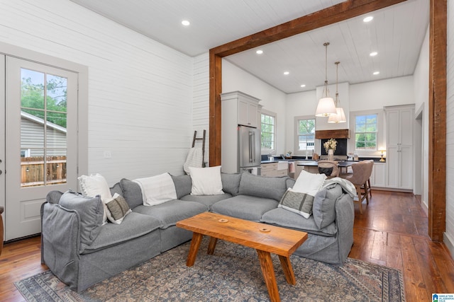 living area featuring dark wood finished floors, beam ceiling, and recessed lighting