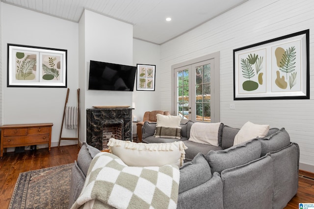 living area with baseboards, recessed lighting, wood finished floors, wooden walls, and a fireplace
