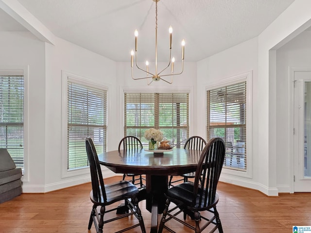 dining area with an inviting chandelier, a healthy amount of sunlight, light wood-style flooring, and baseboards