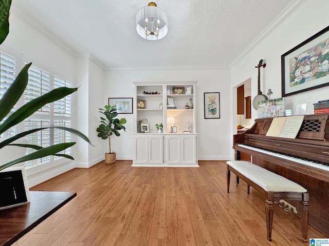 living area with light wood-style flooring, baseboards, a notable chandelier, and ornamental molding