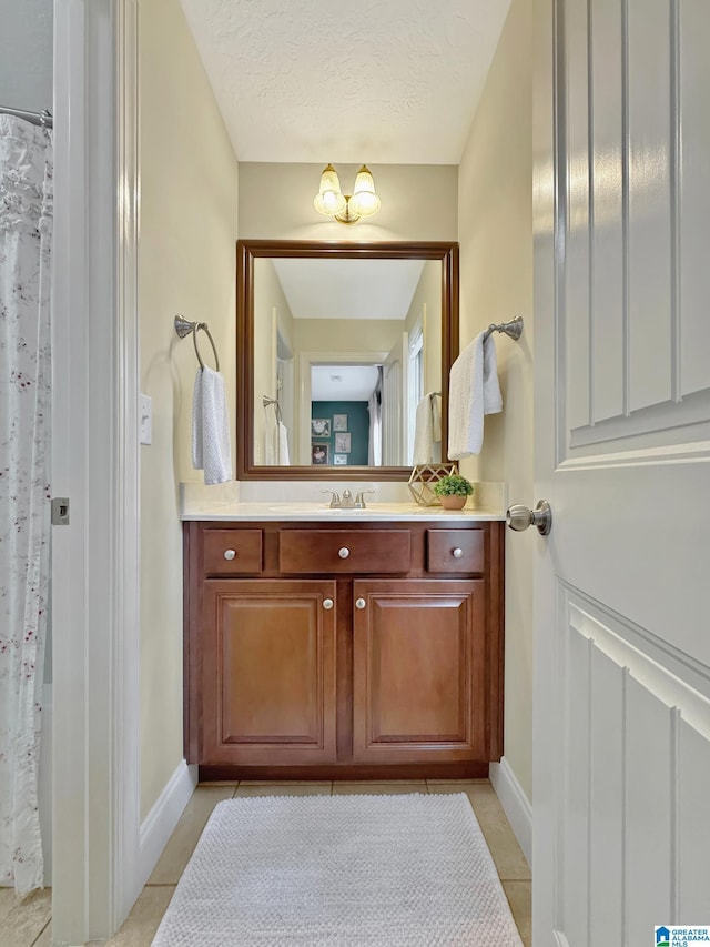 bathroom featuring baseboards, vanity, and tile patterned floors
