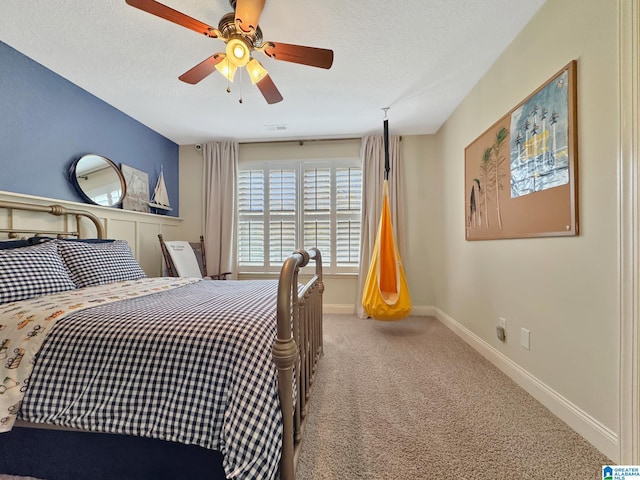 bedroom with a textured ceiling, visible vents, baseboards, carpet, and a ceiling fan