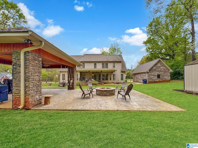 view of patio / terrace featuring a ceiling fan, a fire pit, and an outdoor structure