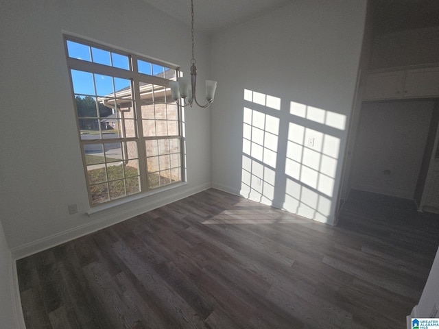 unfurnished dining area with baseboards, a notable chandelier, and dark wood finished floors