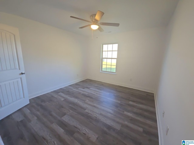 empty room with dark wood-type flooring, baseboards, and ceiling fan
