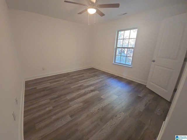 unfurnished room with visible vents, ceiling fan, baseboards, and dark wood finished floors