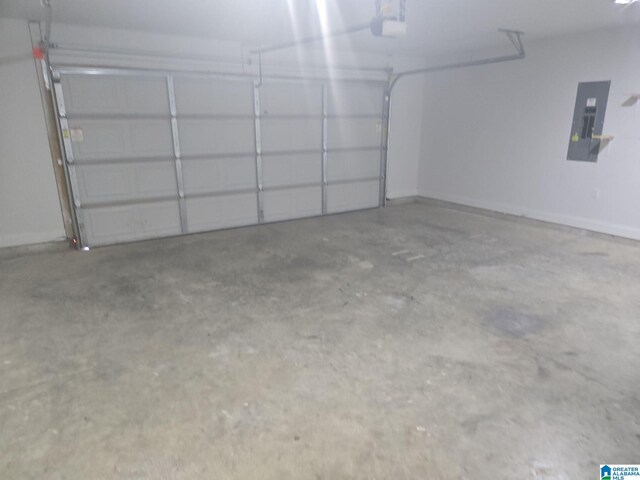 garage with baseboards and electric panel
