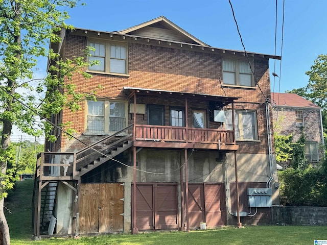 rear view of house featuring brick siding, an attached garage, stairs, and a balcony