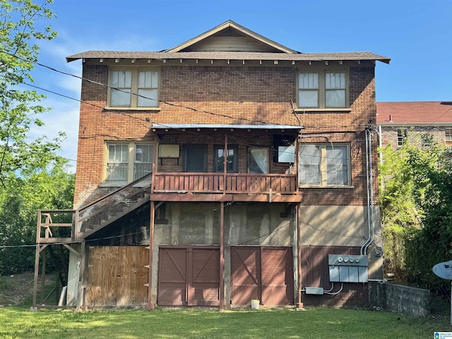rear view of property featuring brick siding and a yard