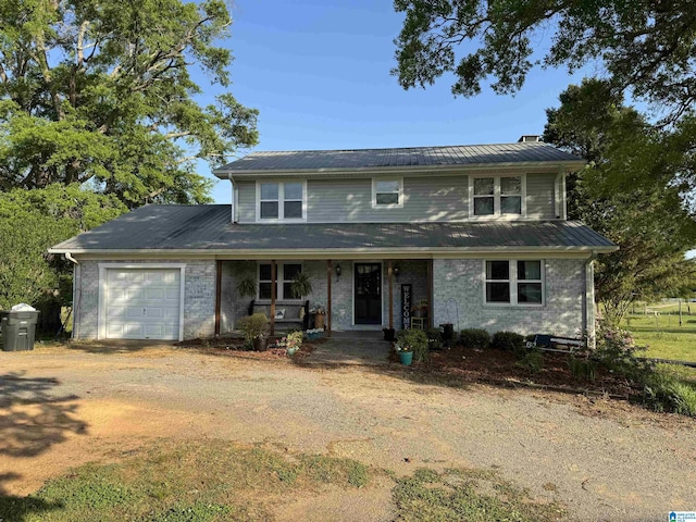 traditional-style home with dirt driveway, an attached garage, a porch, and brick siding