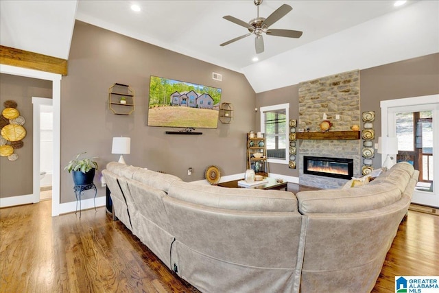 2092 Grey Oaks Ter, Pelham, AL 35124 - living area featuring vaulted ceiling, a healthy amount of sunlight, a ceiling fan, a stone fireplace, and wood finished floors