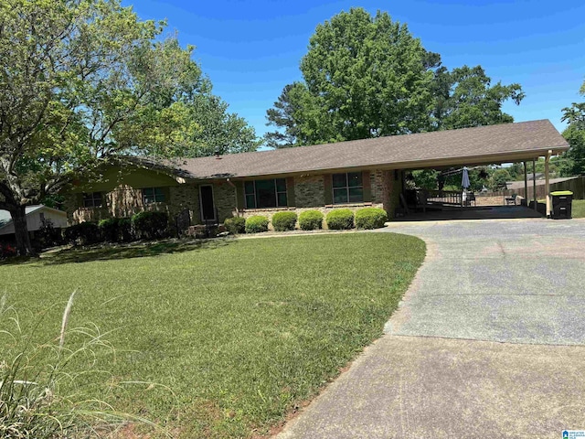ranch-style house featuring driveway, a front yard, a shingled roof, and an attached carport