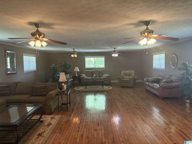 living area with crown molding, hardwood / wood-style floors, ceiling fan, and a wealth of natural light