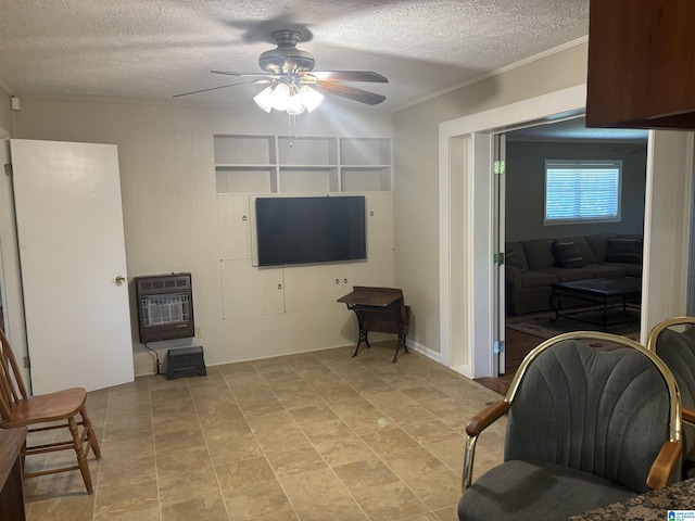 sitting room with ornamental molding, heating unit, a ceiling fan, and a textured ceiling