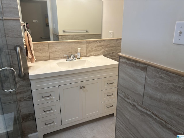 full bath featuring a wainscoted wall, tile walls, and vanity