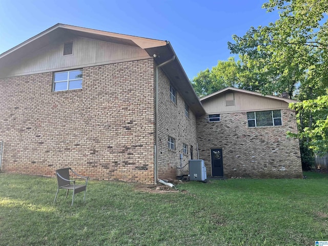 view of property exterior featuring a yard, central air condition unit, and brick siding