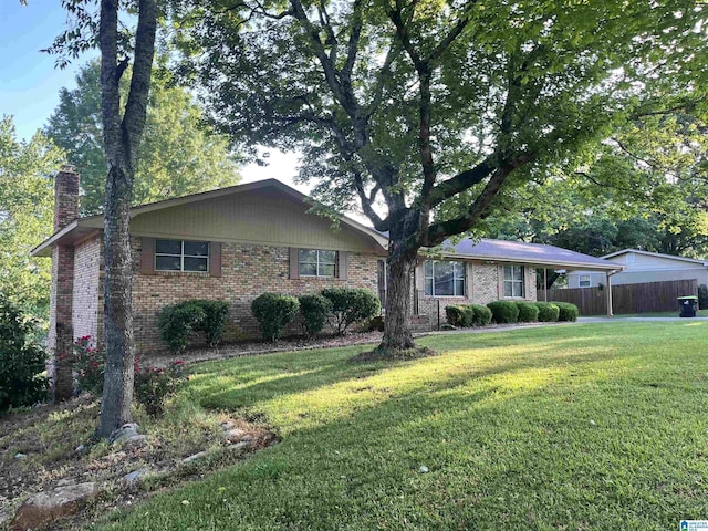 single story home with fence, a chimney, a front yard, and brick siding