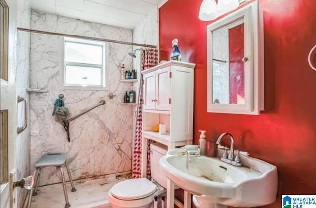 bathroom featuring toilet, a sink, and a marble finish shower