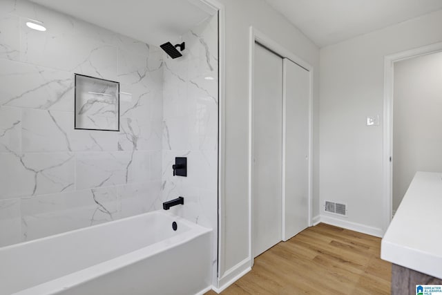 full bathroom featuring wood finished floors, vanity, shower / washtub combination, baseboards, and visible vents