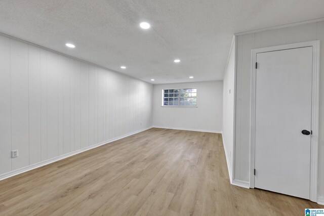 interior space with recessed lighting, a textured ceiling, light wood finished floors, and baseboards