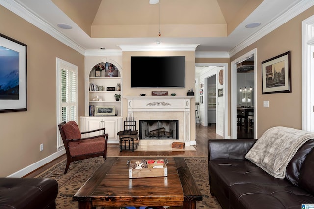 living area with ornamental molding, dark wood-style floors, built in features, and a fireplace