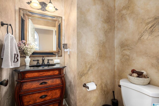 half bathroom with vanity and toilet